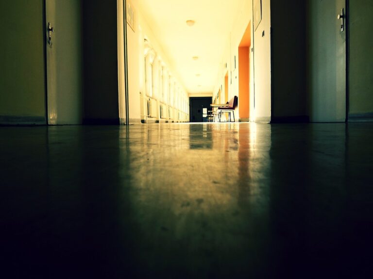 Long, quiet hospital corridor with shiny floors and warm light at the far end