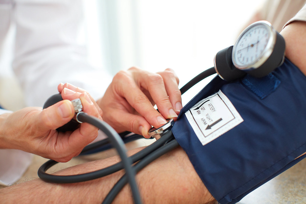 Doctor measuring a patient's blood pressure with a cuff and gauge