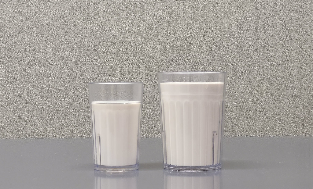 Two clear glasses of fresh white milk standing side by side on a table
