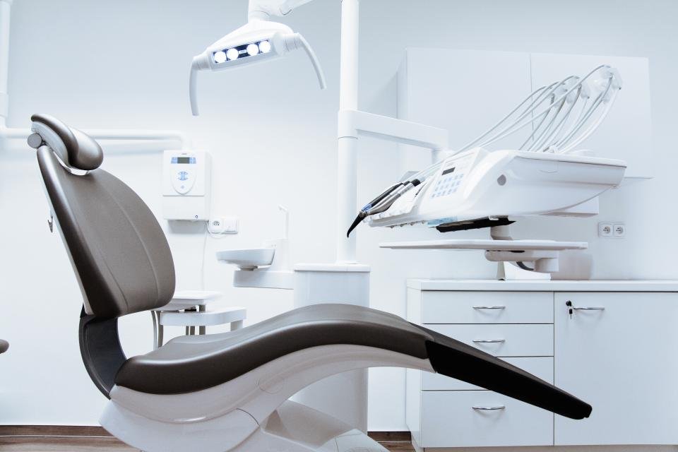 Bright, clean modern clinic treatment room with a patient chair and equipment